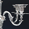 Ornate detailing to two of the branches of the silver candelabra