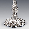Base of silver candlestick showing flora and fauna chased detail
