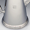 Lower side of coffee pot showing engraved initials TTA