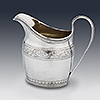Hand engraved sterling silver cream jug with floral detail and cartouche